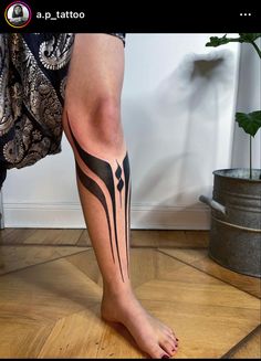 a woman's leg with a tattoo design on the bottom part of her legs