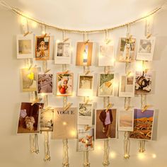 a bunch of pictures hanging on a wall with lights around them and some string lights