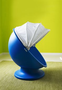 a blue ball with a tissue paper in it sitting on the floor next to a green wall