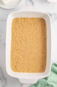 a white dish filled with brown sugar next to other ingredients on a marble counter top