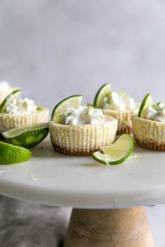 mini cucumber tarts with limes and whipped cream on a cake plate