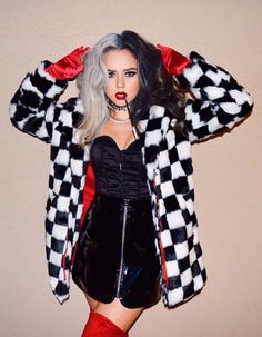 a woman in a black and white checkered jacket with red boots posing for the camera