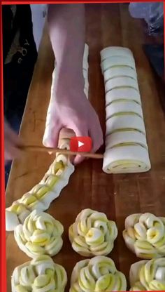 a person cutting up some food on a wooden table