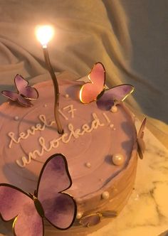 a birthday cake with two butterflies on it and a lit candle in the middle that says, i love you