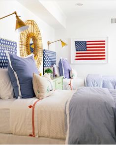 an instagram photo of a bedroom with blue and white bedding, american flag on the wall