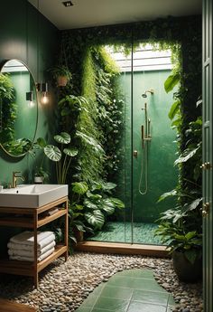 a bathroom with green walls and plants on the wall, along with a walk in shower