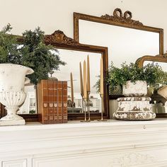 there is a mantle with books and vases on it in front of the mirror