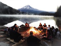 a group of people sitting around a campfire