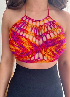 a woman wearing an orange and pink crochet top