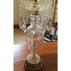 a glass table lamp sitting on top of a wooden table