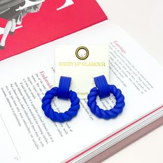 Made to Party Twisted Circle Earrings in Royal Blue. Pictured on an open page of a book. Bold Blue Jewelry For Party, Bold Blue Drop Earrings, Bold Blue Earrings For Gift, Trendy Blue Drop Earrings, Giddy Up Glamour, Earrings Red, Matching Necklaces, Circle Earrings, Ear Piercings