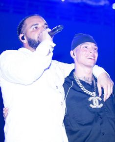 two men standing next to each other on stage