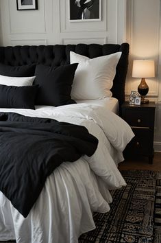 a black and white bed in a bedroom with pictures on the wall behind it,