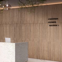 an office lobby with wooden walls and white pedestals