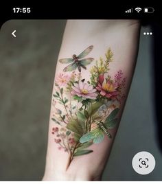 a woman's arm with flowers and dragonflies on it