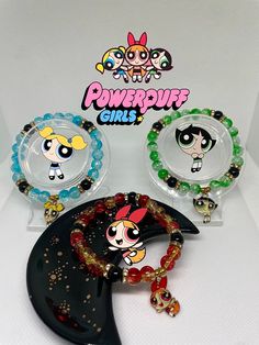 the powerpuff girls bracelets are on display in front of some other items