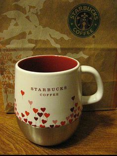 a starbucks coffee cup sitting on top of a wooden table