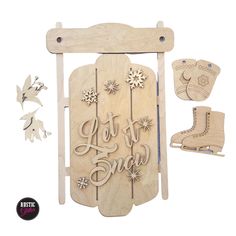 a wooden sled with snowflakes and some cutouts on the front, along with an ornament that says let it snow