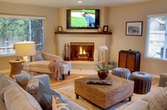 a living room filled with furniture and a flat screen tv mounted on the wall above a fire place