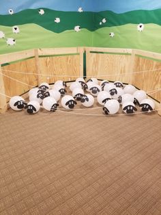 stuffed sheep are tied up in a fenced area with wooden posts and fencing around them