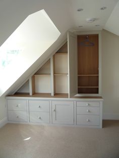 an attic bedroom with built in cabinets and cupboards