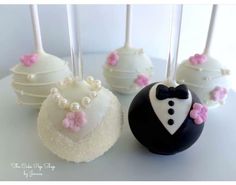 four cake pops decorated with white and pink frosting, one in a tuxedo