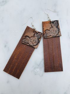 Made to order hand rose tooled brown fringe leather earrings These are the perfect balance of rustic and feminine Each pair is made just for you when you order them, so variations will occur These will be finished with sterling Silver plated over steel ear wires Drop length approximately 3 1/2" x 1" width Thank you for shopping @boholeathercraft ! Let's be friends on Instagram & Facebook Follow me for sneak peaks and the occasional promo code and giveaway! Custom Leather Work, Hand Rose, Food On The Table, Earrings Western, Brown Fringe, Heavy Earrings, Cowgirl Jewelry, Leather Bar, Western Jewelry