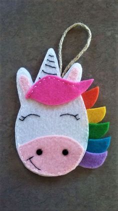 a felt unicorn ornament hanging from a string