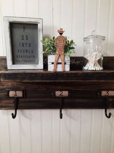 there is a shelf with two hooks on it and a wooden man figurine