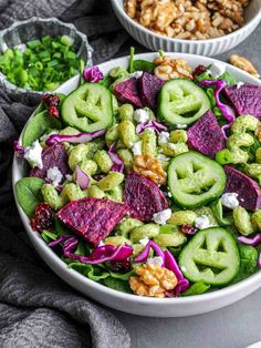 a salad in a white bowl with purple cabbage and walnuts next to the salad