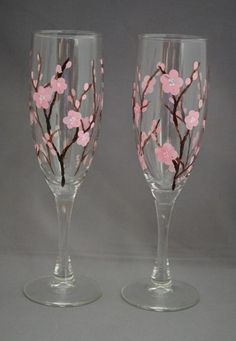 two wine glasses with pink flowers painted on them