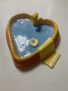 a yellow and red heart shaped dish with a banana peel sticking out of it