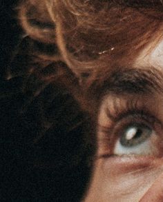 a close up of a person's face with blue eyes