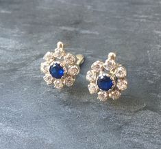 Description: Vintage Earrings set with a Created Sapphire in a diamond cut, flawless clarity & royal blue color, surrounded by small CZ Diamonds, 4 Carats a pair.  Vintage Flower Earrings design made of Solid 925 Sterling Silver ☞ made to last.  Matching Ring: www.etsy.com/uk/listing/466329768 Matching Pendant - please ask me  ⌛ Last pair left ⌛    For Pierced Ears - has a pin that goes into the ear and a leaver that securely closes on the pin behind the earlobes - " English Lock "  Details :  ♥ Blue Cluster Earrings For Anniversary, Sapphire Diamond Earrings For Wedding, Classic Blue Diamond Earrings For Wedding, Sapphire Earrings With Multiple Jewels, Sapphire Earrings With 17 Jewels For Gift, Classic Sapphire Diamond Earrings For Wedding, Blue Diamond Round Earrings For Wedding, Sapphire Diamond Cut Earrings For Wedding, Blue Diamond Earrings For Wedding