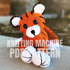 a knitted stuffed animal sitting on top of a table with the words knitting machine written below it