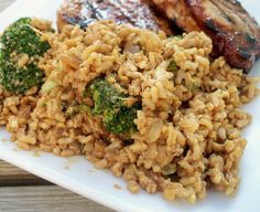 meat and rice with broccoli on a white plate