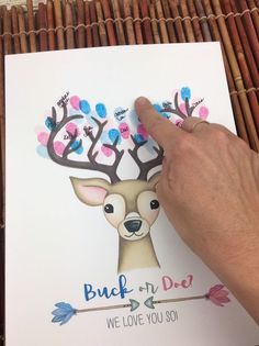 a hand is pointing at a greeting card with an image of a deer