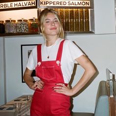 a woman standing in front of a kitchen counter with her hands on her hips and wearing an apron