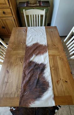 a cowhide table runner on top of a wooden table