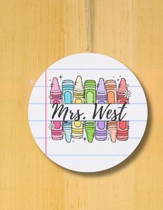 a round sticker with the words mrs west written in black on top of it