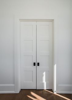 an empty room with two white doors in it