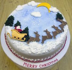 a christmas cake with santa riding in a sleigh and reindeers on it