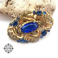 Beautiful vintage oval floral filigree Czech brass brooch with blue bohemian glasses. It is in a very good vintage condition. A rare and collectible piece. The size is: 3.5x5.5 cm This elegant large brooch could be a nice present for collectors or for beautiful brooch lovers. Please feel free to contact me if you have any questions. Check out my shop where you can find a lot of interesting brooches. Thank you for visiting my shop. Blue Oval Brooch Jewelry, Blue Oval Brooch For Gifts, Oval Blue Brooch Jewelry, Oval Blue Brooch, Vintage Sapphire Brooch Jewelry, Ornate Blue Brooch For Formal Occasions, Blue Oval Brooch, Ornate Blue Brooches For Wedding, Ornate Blue Wedding Brooches