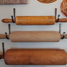 three rolling doughs are hanging on the wall next to other baking supplies and utensils