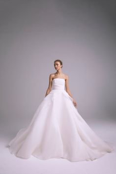 a woman in a white wedding dress posing for the camera with her hands on her hips