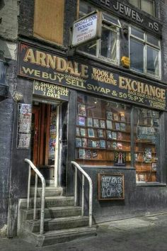 an old building with many signs on the front and stairs leading up to it's entrance