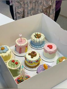 a box filled with lots of different types of cakes on top of white counter tops