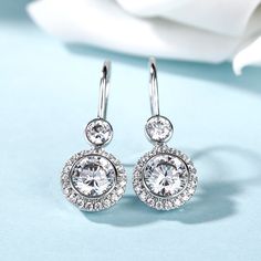 This beautiful style is a perfect gift for any lady or the perfect reason to spoil yourself! Designed in sterling silver, each earring features a sparkling round cut stone wrapped in a glistening halo as the drop. All stones glisten with every beat of her heart and every turn of her head. Celebrate your sweetheart with these sweet drop earrings.Carat Weight: 5 ctStone Size: 7 mmStone Type: Jeulia® StoneNumber of Stones: 2 Stone Color: Diamond WhiteStone Shape: RoundCarat Weight: 1.29 ctStone Siz Formal Halo Design Round Earrings, Formal Round Halo Earrings, Formal Round Halo Design Earrings, Round Halo Design Formal Earrings, Elegant Round Cut Halo Cluster Earrings, Fine Jewelry Halo Design Round Cut Earrings, Elegant Round Cut Cluster Earrings With Halo Setting, Halo Round Earrings For Formal Occasions, Fine Jewelry Halo Design Drop Earrings