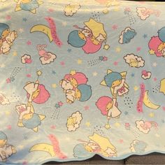 a blanket with cartoon characters on it and stars in the sky above them, as well as other items