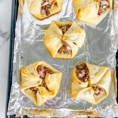 several pastries sitting on top of aluminum foil